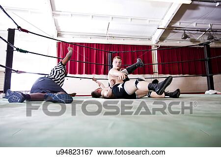 Wrestlers pinning down rival while referee counting during match View Large Photo Image Stock Photo - Wrestlers pinning down rival while referee counting during match. Fotosearch