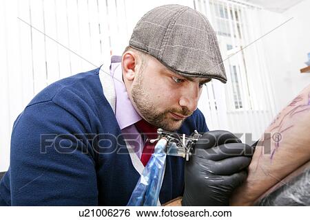 Young artist tattooing man's arm in tattoo parlor View Large Photo Image Stock Photograph - Young artist tattooing man's arm in tattoo parlor. Fotosearch