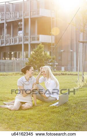 Young businesswomen gossiping in office lawn View Large Photo Image Stock Photography - Young businesswomen gossiping in office lawn. Fotosearch