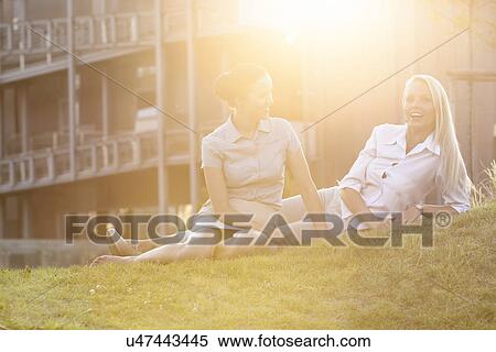 Young businesswomen relaxing on office lawn View Large Photo Image Stock Photography - Young businesswomen relaxing on office lawn. Fotosearch
