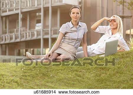 Young businesswomen with laptop on office lawn View Large Photo Image Picture - Young businesswomen with laptop on office lawn. Fotosearch