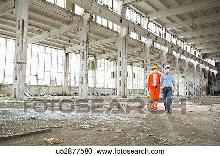 Full length of construction workers in protective workwear walking at site View Large Photo Image Stock Image - Full length of construction workers in protective workwear walking at site. Fotosearch