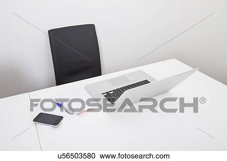 Laptop on desk in empty office View Large Photo Image Stock Image - Laptop on desk in empty office. Fotosearch