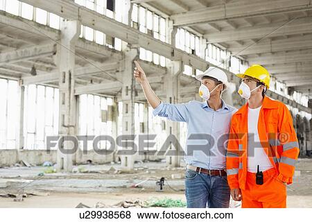 Male construction worker discussing at site View Large Photo Image Stock Photo - Male construction worker discussing at site. Fotosearch