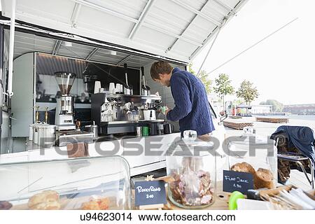 Picture - Man cleaning coffee machine at mobile shop. Fotosearch