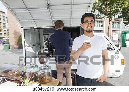 Portrait of customer holding disposable coffee cup against vendor and mobile shop View Large Photo Image Stock Photo - Portrait of customer holding disposable coffee cup against vendor and mobile shop. Fotosearch