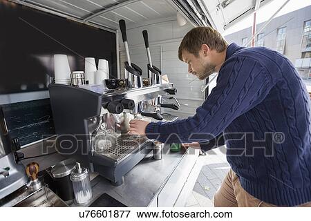 Side view of young man cleaning coffee machine View Large Photo Image Stock Photo - Side view of young man cleaning coffee machine. Fotosearch
