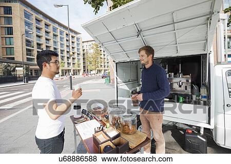 Stock Photo - Vendor looking customer at mobile coffee shop on street. Fotosearch