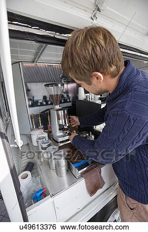 Young man preparing coffee in mobile coffee shop View Large Photo Image Stock Photograph - Young man preparing coffee in mobile coffee shop. Fotosearch