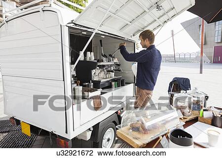Stock Image - Young man working at mobile coffee shop. Fotosearch