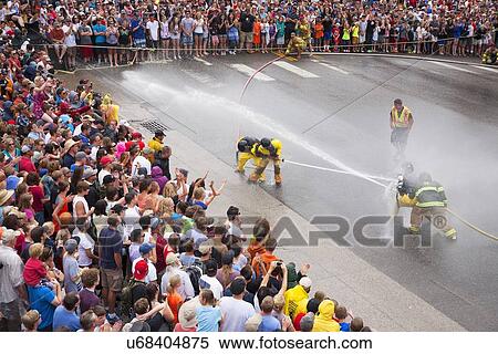 Stock Photography - Men dressed in yellow firemen slickers and firehoses have annual Waterfight on July 4, Ouray, CO. Fotosearch