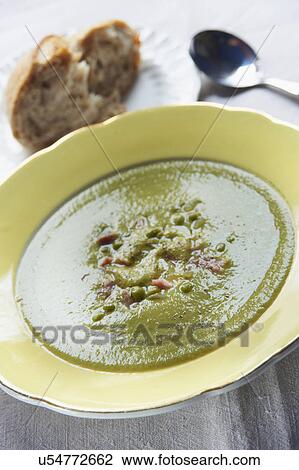 Stock Image - Bowl Of Pea And Ham Soup Served With Bread. Fotosearch