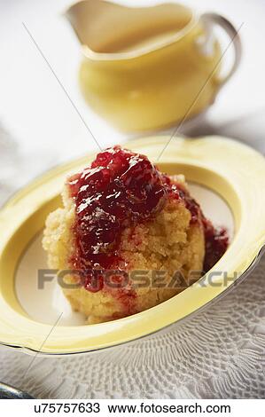 Stock Image - Bowl Of Steamed Jam Pudding With Jug Of Custard. Fotosearch