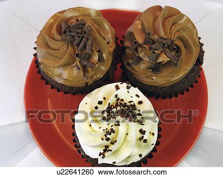 Stock Image - Chocolate And Vanilla Cupcakes On Plate In Studio. Fotosearch