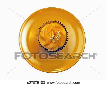 Stock Image - Overhead Of Single Orange Cupcake With Icing. Fotosearch