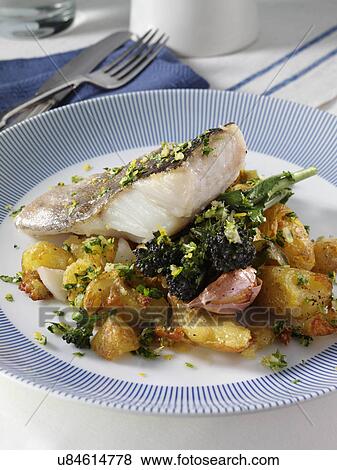 A baked fillet of pollock on a bed of crispy crushed Charlotte potatoes with purple sprouting broccoli sage and garlic and gremolata sauce View Large Photo Image Stock Photo - A baked fillet of pollock on a bed of crispy crushed Charlotte potatoes with purple sprouting broccoli sage and garlic and gremolata sauce. Fotosearch