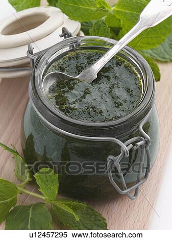Stock Photography - A jar of mint sauce with a spoon and fresh leaves. Fotosearch