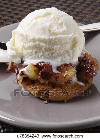 Stock Image - A scoop of ice cream on a chocolate chip cookie. Fotosearch