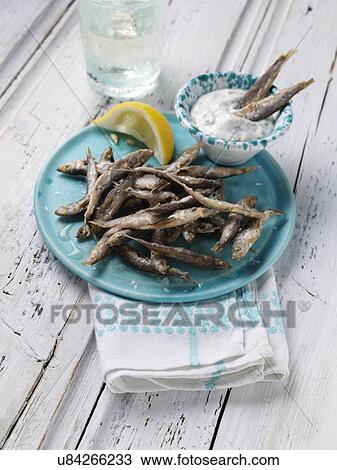 Stock Image - A single serving of deep fried whitebait with tartare sauce dip. Fotosearch