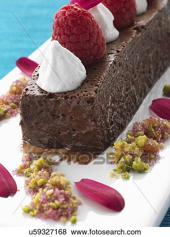 Stock Photo - A whole chocolate marquise with raspberries and cream gourmet dessert. Fotosearch