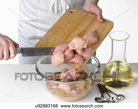 Stock Photo - Adding chicken pieces to a marinade. Fotosearch
