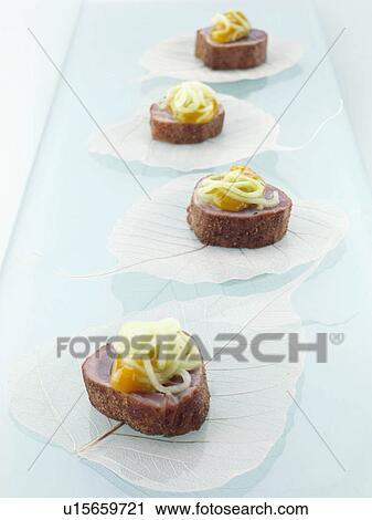 Stock Image - Asian tuna canape mango cucumber. Fotosearch