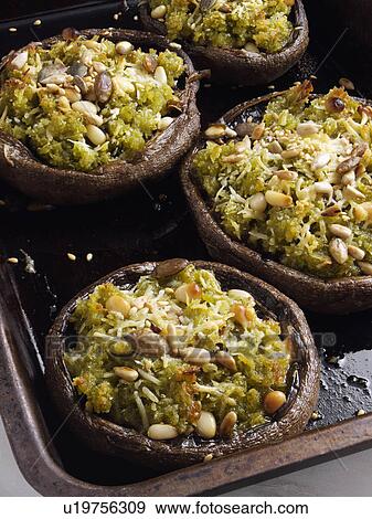 Stock Photo - Baked pesto stuffed mushrooms in a roasting tin. Fotosearch