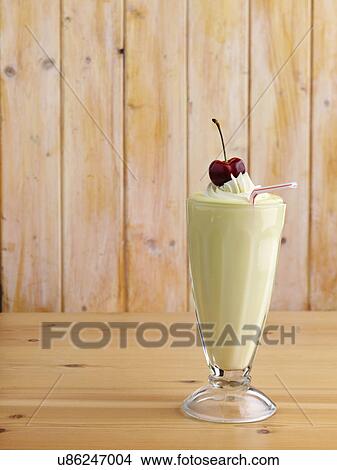 Banana milkshake with whipped cream topping and a ripe cherry on top View Large Photo Image Picture - Banana milkshake with whipped cream topping and a ripe cherry on top. Fotosearch