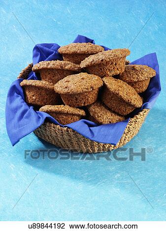 Stock Image - Basket Full Of Bran Muffins On Blue. Fotosearch