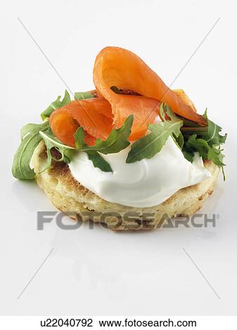 Stock Image - Blin with smoked salmon rocket leaves. Fotosearch