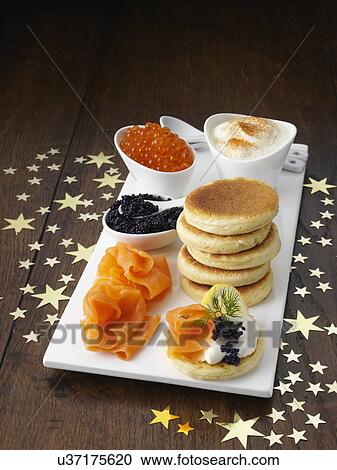 Stock Image - Blini with smoked salmon salmon roe and sour cream. Fotosearch
