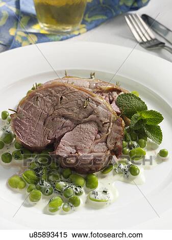 Stock Photography - Boned roast leg of lamb slices with creamy peas and broad beans. Fotosearch