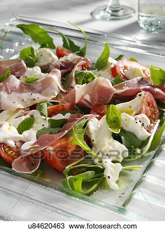 Stock Image - Burrito prosciutto ham and tomato salad. Fotosearch