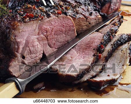 Stock Image - Butterflied leg of lamb marinaded and barbecued. Fotosearch