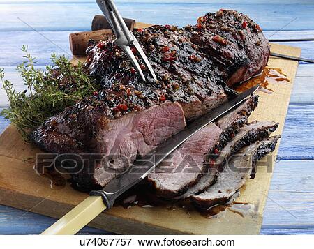 Stock Photo - Butterflied leg of lamb marinaded and barbecued. Fotosearch