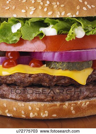 Cheeseburger with two beef patties lettuce red onion gherkin mayonnaise and tomato ketchup close up View Large Photo Image Stock Image - Cheeseburger with two beef patties lettuce red onion gherkin mayonnaise and tomato ketchup close up. Fotosearch