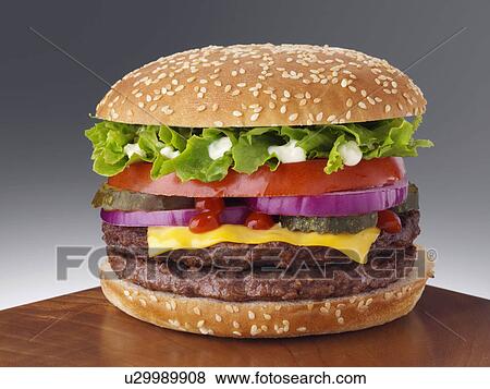 Cheeseburger with two beef patties lettuce red onion gherkin mayonnaise and tomato ketchup View Large Photo Image Stock Photo - Cheeseburger with two beef patties lettuce red onion gherkin mayonnaise and tomato ketchup. Fotosearch