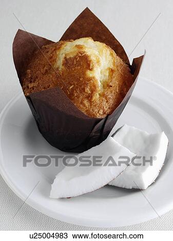 Stock Image - coconut muffin with pieces of coconut on a white plate. Fotosearch