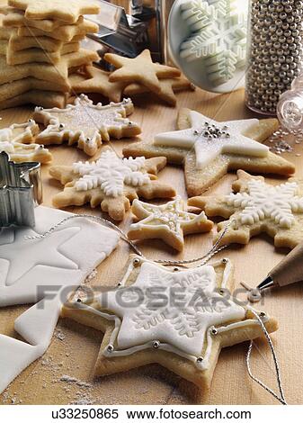 Stock Photography - Decorating Christmas biscuits with white icing. Fotosearch