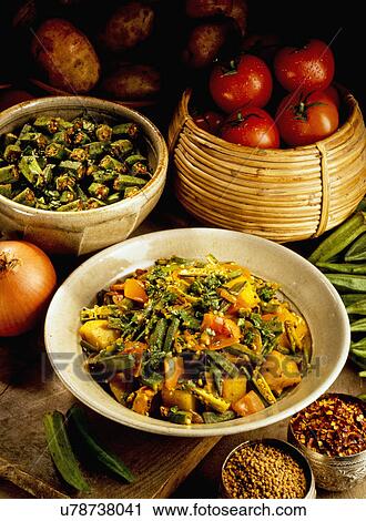 Dish With Aloo Bhindi Or Potato And Okra Curry, Bowl Of Chopped Okra And Basket With Tomatoes, Tabletop With Spices And Vegetables View Large Photo Image Stock Image - Dish With Aloo Bhindi Or Potato And Okra Curry, Bowl Of Chopped Okra And Basket With Tomatoes, Tabletop With Spices And Vegetables. Fotosearch