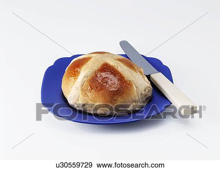 Stock Photo - Easter hot cross bun on a blue plate on a white background. Fotosearch