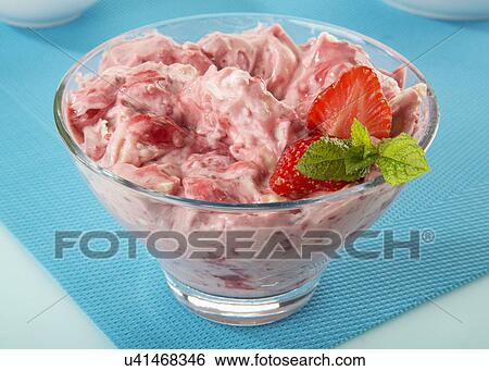 Stock Photograph - Glass Bowl Filled With Eton Mess Dessert, Strabwrries, Meringue And Fresh Whipped Cream, Turquoise Tabletop. Fotosearch