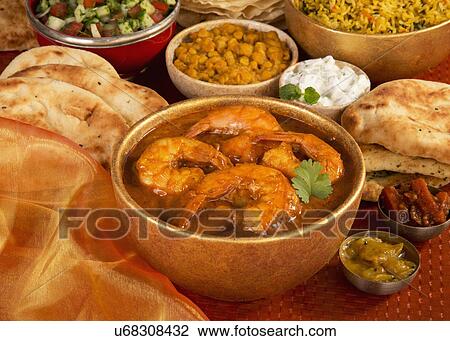 Stock Image - Goan Prawn Curry Dish With Naan Bread, Rice, Salad And Lentil Dish, Golden. Fotosearch