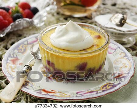 Stock Image - Individual blueberry clafoutis on a garden table. Fotosearch