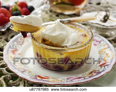 Stock Photography - Individual blueberry clafoutis on a garden table. Fotosearch