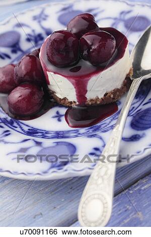 Stock Photograph - Individual cherry cheesecake on an antique plate. Fotosearch