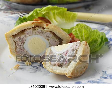 Stock Image - Individual pork pie with a quail egg inside. Fotosearch