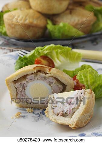 Stock Image - Individual pork pie with a quail egg inside. Fotosearch