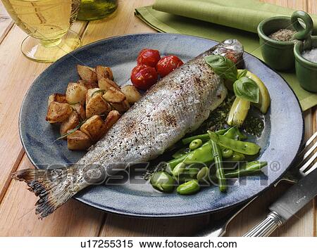 Stock Photography - Individual portion of broiled rainbow trout and saute potatoes tomatoes with green bean salad. Fotosearch