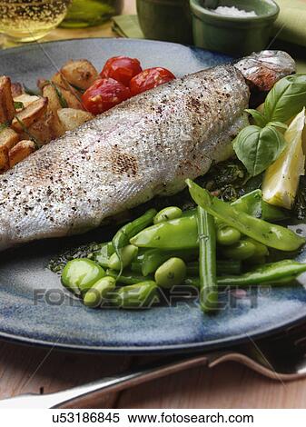 Stock Photography - Individual portion of broiled rainbow trout and saute potatoes tomatoes with green bean salad. Fotosearch